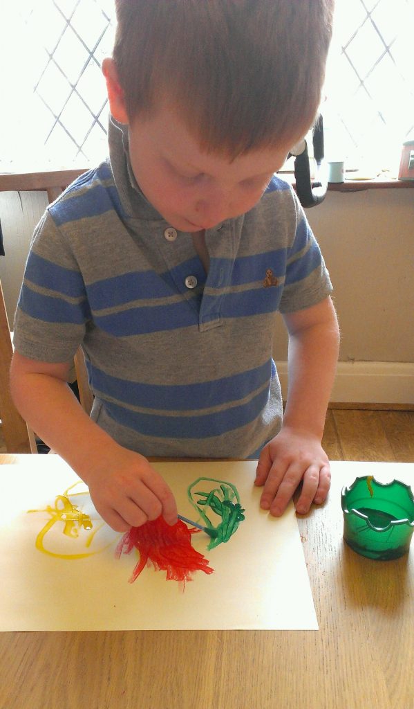 Little boy painting with cotton buds