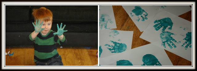 toddler making green hand prints for a Christmas craft - festive wreath