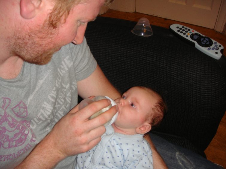Daddy bottle feeding baby girl expressed breast milk (Breast milk pumping)