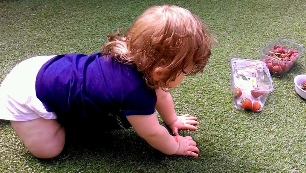 Amy on her hands and knees trying to crawl for the first time