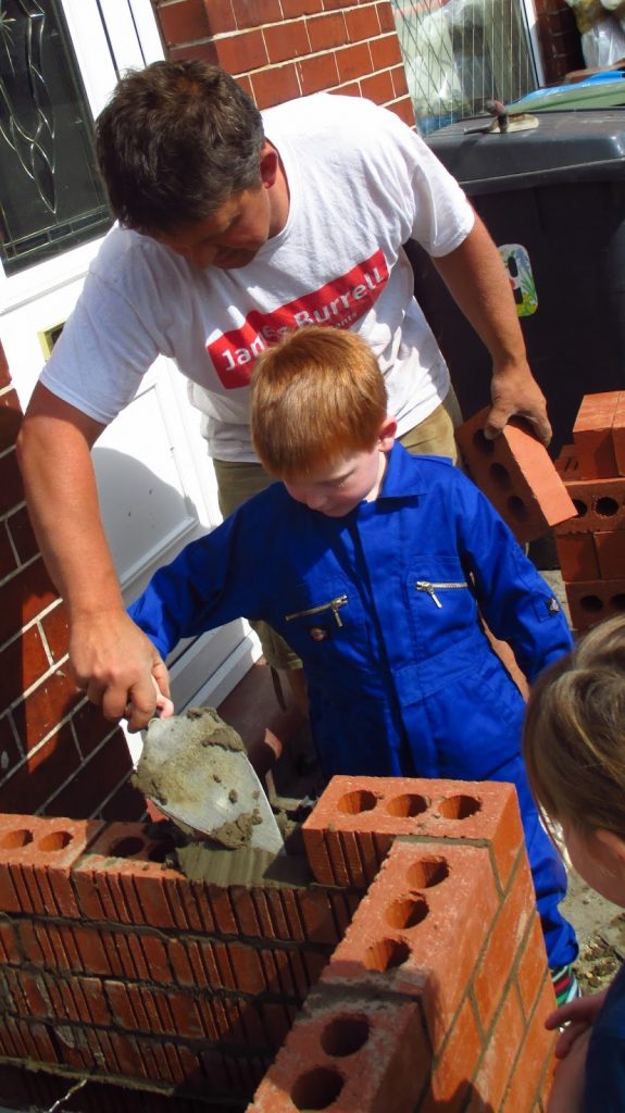 Tim and Ben laying bricks together