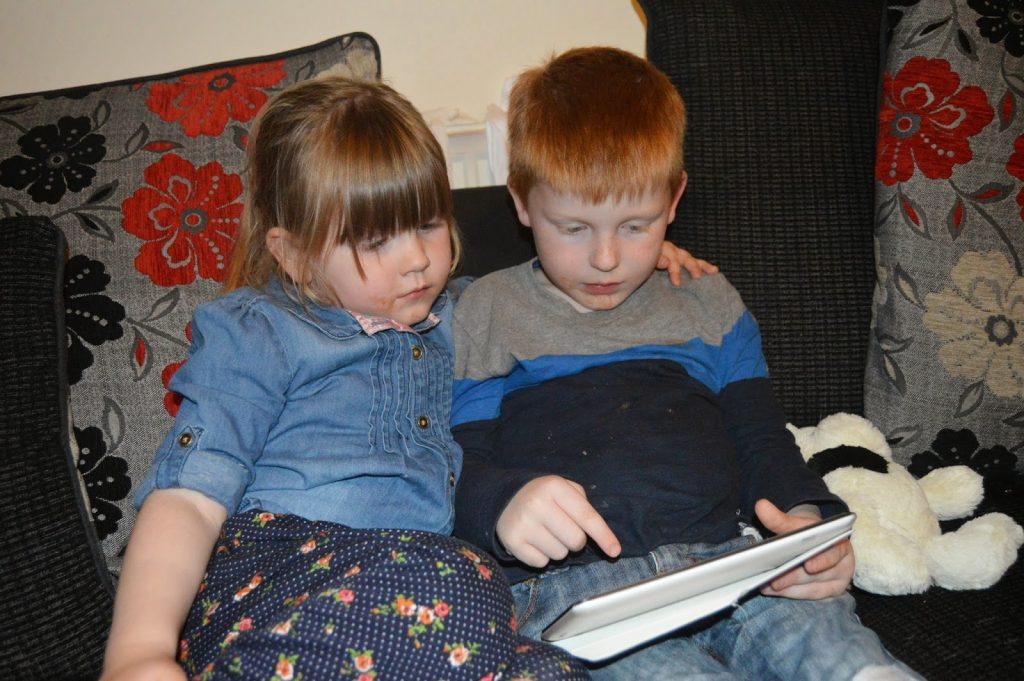 Brother and sister using the Oxford Reading Tree app to practice their reading at home