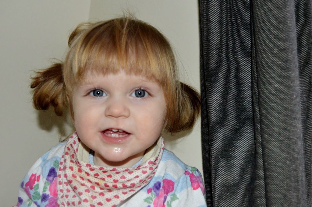 14 month old Amy with her hair in bunches and a dribbly chin