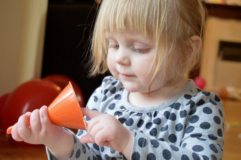 toddler investigating funnel