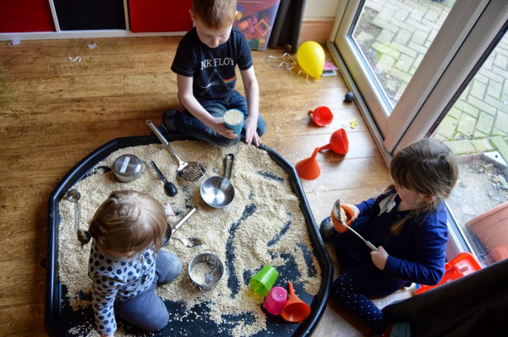 kids playing in tuff spot with oats