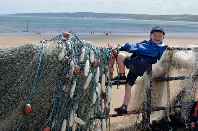 Climbing on the railings next to some fishing nets in Filey