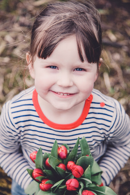 Little girl with a bunch of red tulips - photo by Sally Langstaff