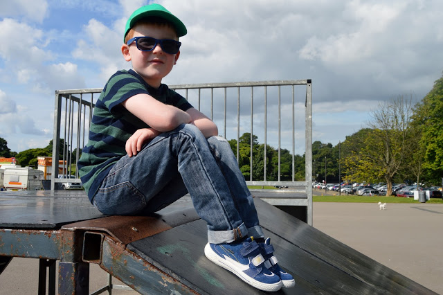 Child sitting at the top of skate board ramp in Heaton Park