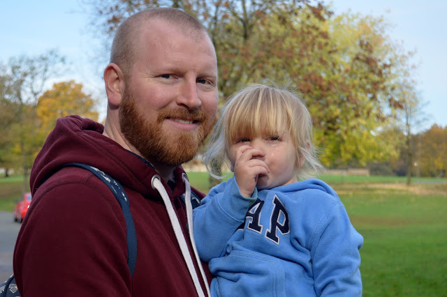 Sad little girl sucking her thumb and getting cuddles from daddy