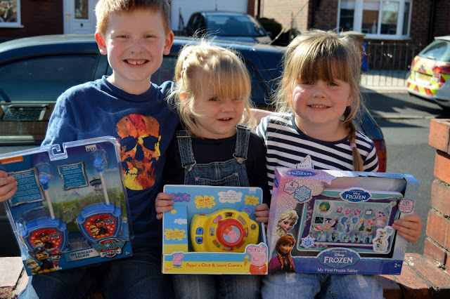 Children sitting on wall with a range of toys from KD UK toys