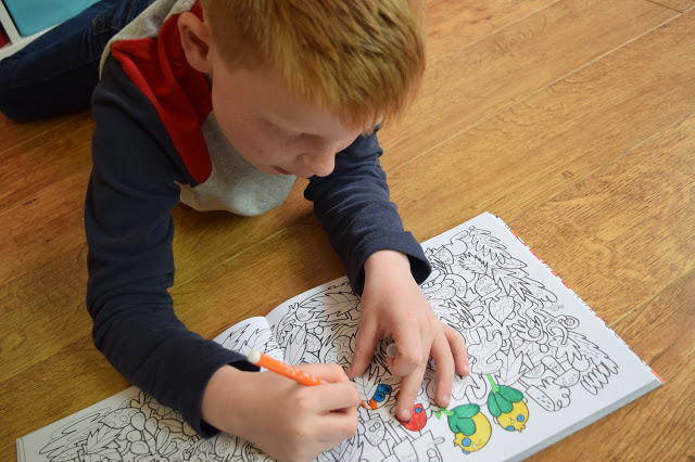 boy colouring in monster colouring book