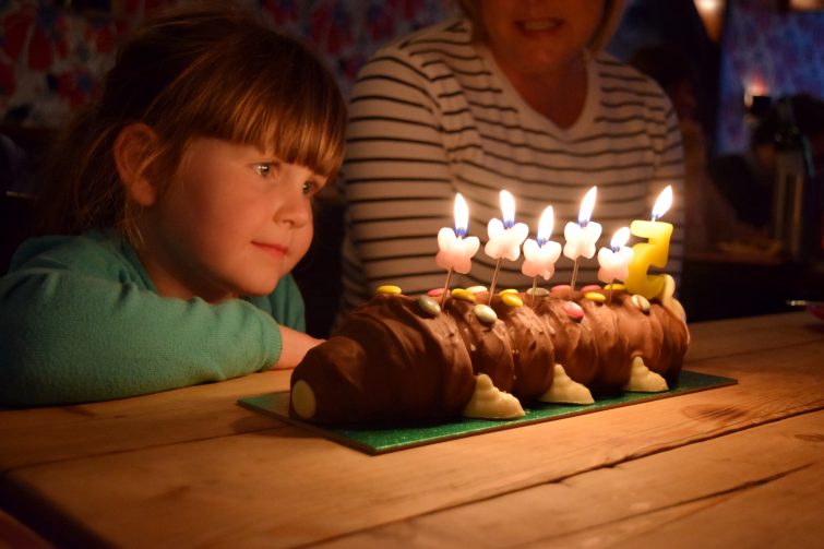 Little girl with birthday cake and candles