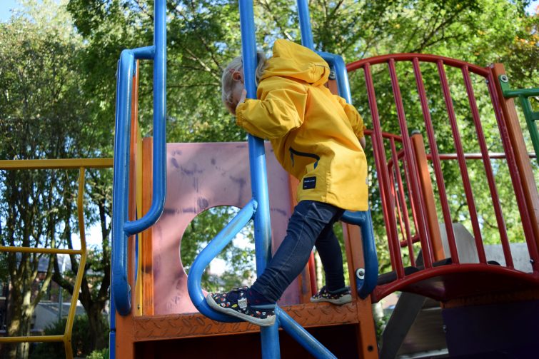 Amy climbing in her Polarn O. Pyret Yellow Shell Jacket