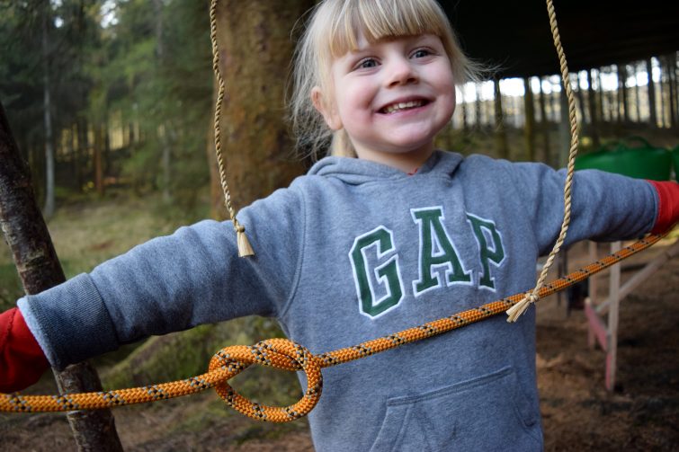 Little girl learning to tie knots