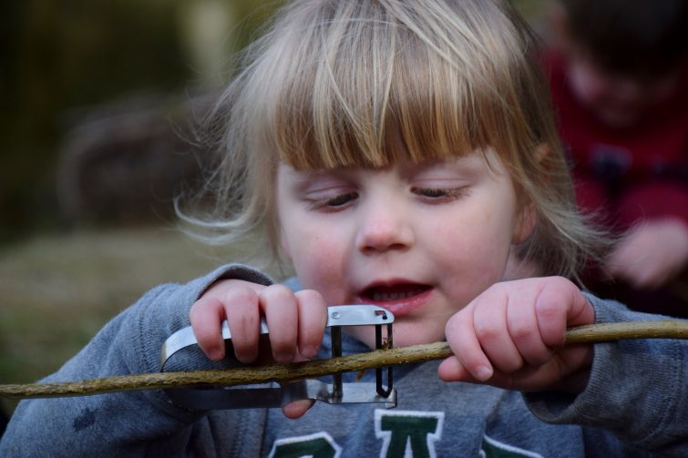 Peeling the bark off a stick for marshmallow toasting