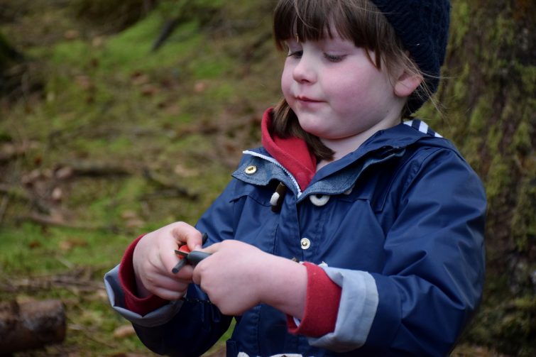 Chloe having a go at lighting the fire with a flint & steel