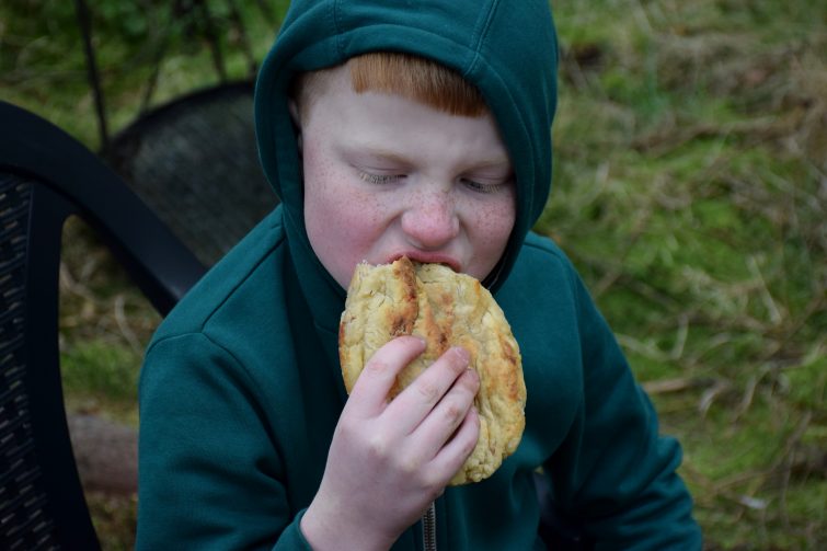 Ben tucking into his campfire pizza bread