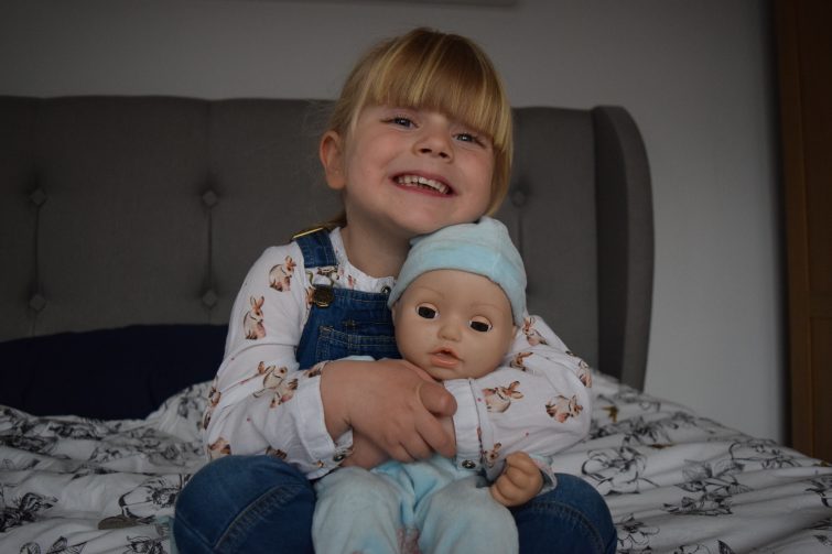Little girl with Baby Annabell's brother
