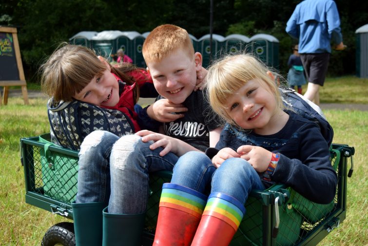 kids sitting in a festival trolley at Just So Festival