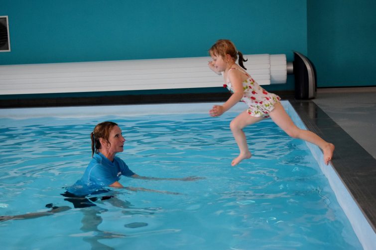Little girl leaping into the swimming pool
