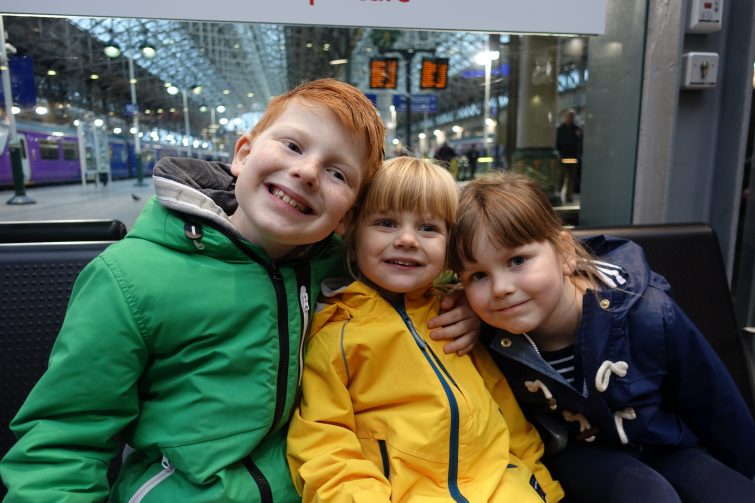 Kids waiting to get on the train at Manchester Piccadilly Station - making use of a family and friends railcard to save money on rail travel