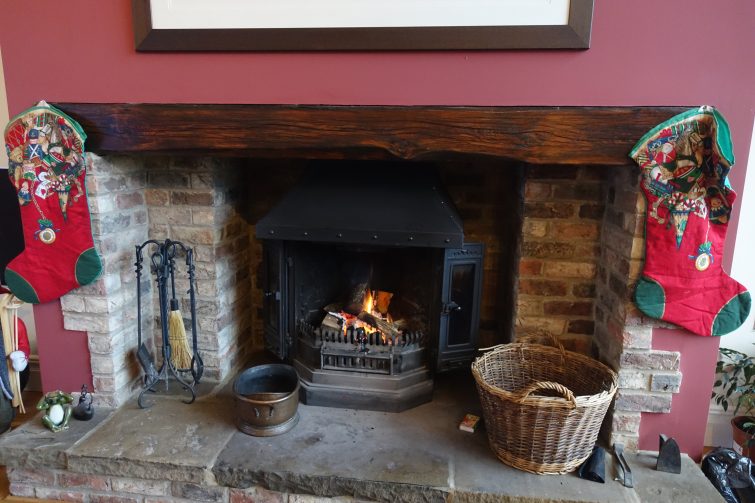 a festive fireplace hung with stockings and a real coal fire