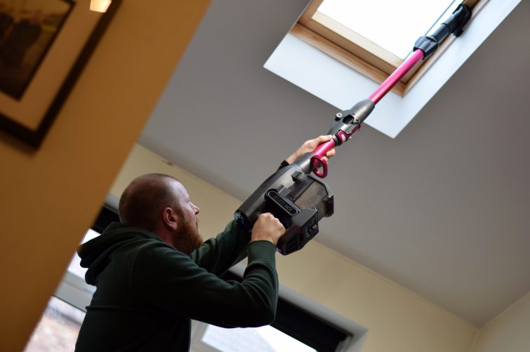 Cleaning skylight with vacuum cleaner. Shark cordless cleans high up spaces with ease