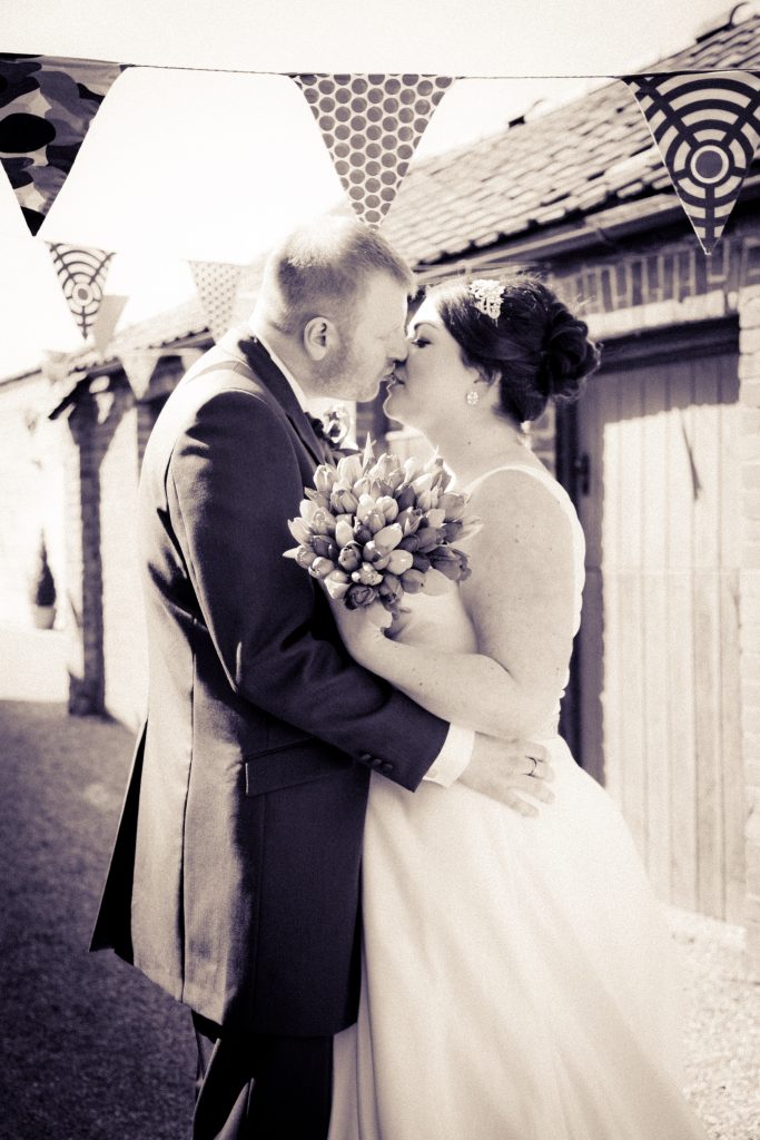 Bride and groom under bunting at York Maze