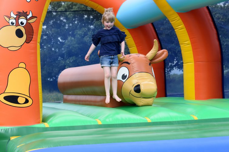 Little girl jumping on bouncy castle at Chateau de Lez Eaux campsite