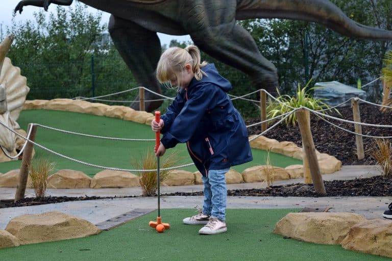Little girl playing crazy golf near the Trafford Centre