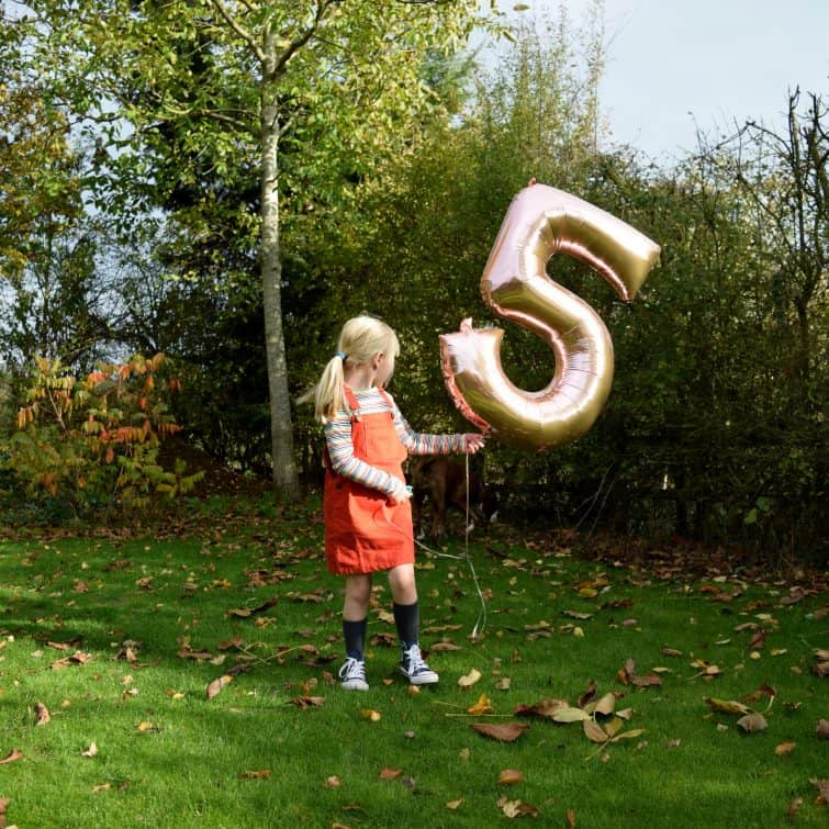 Little girl with helium balloon on 5th birthday