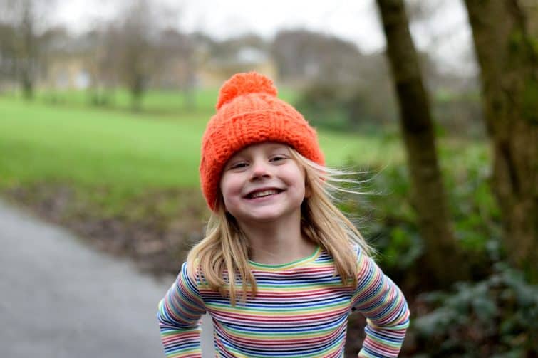 cheeky little girl in orange bobble hat