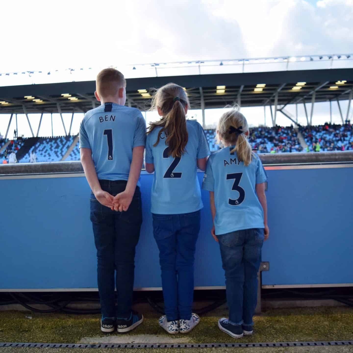 Siblings wearing Manchester City shirts.