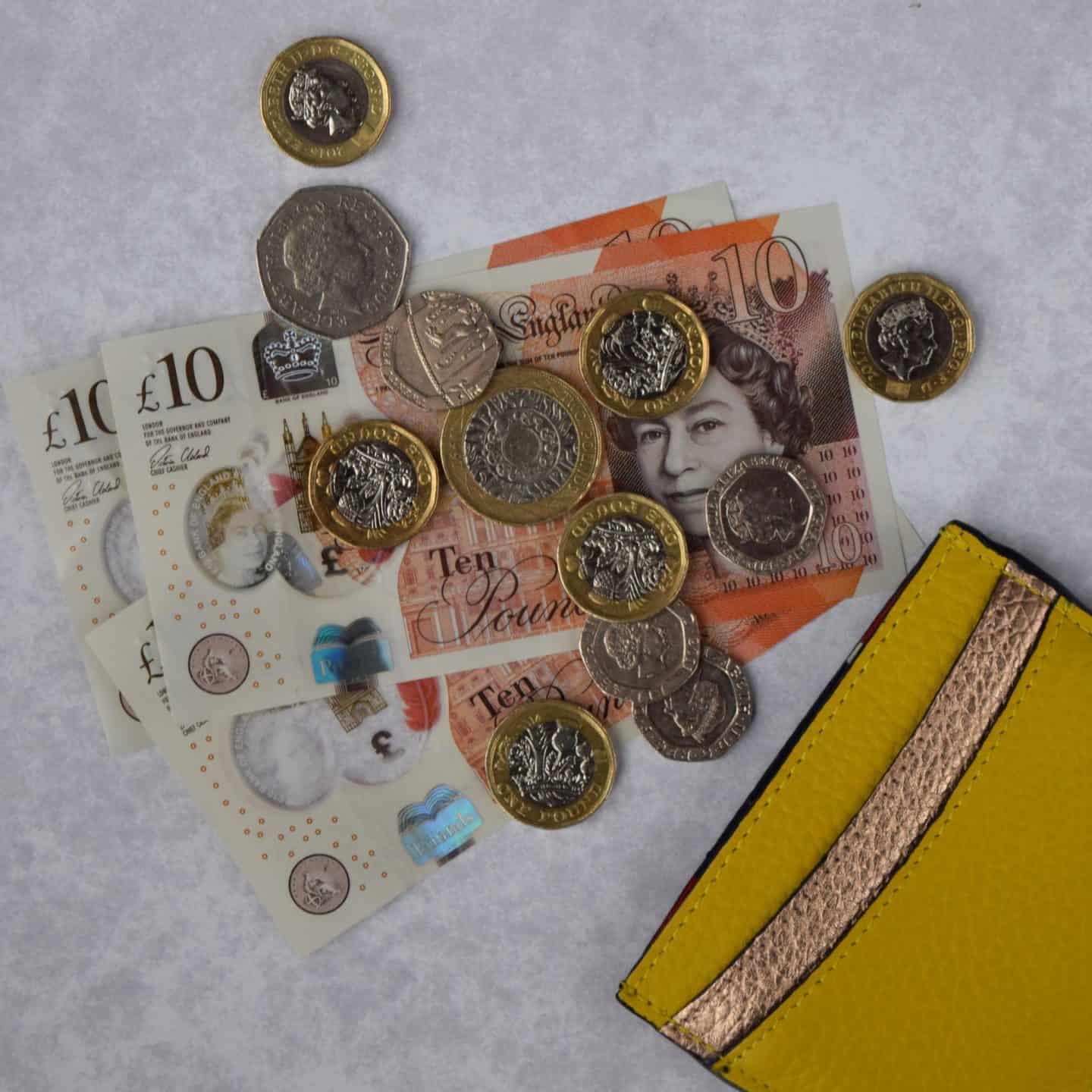 Collection of British coins spilling from purse