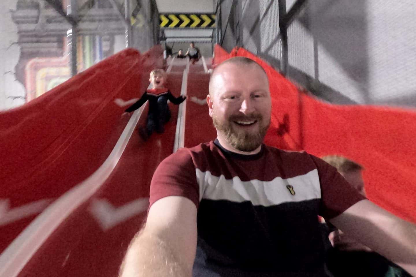 Dad taking a selfie with his daughter on the slide at Play Factore