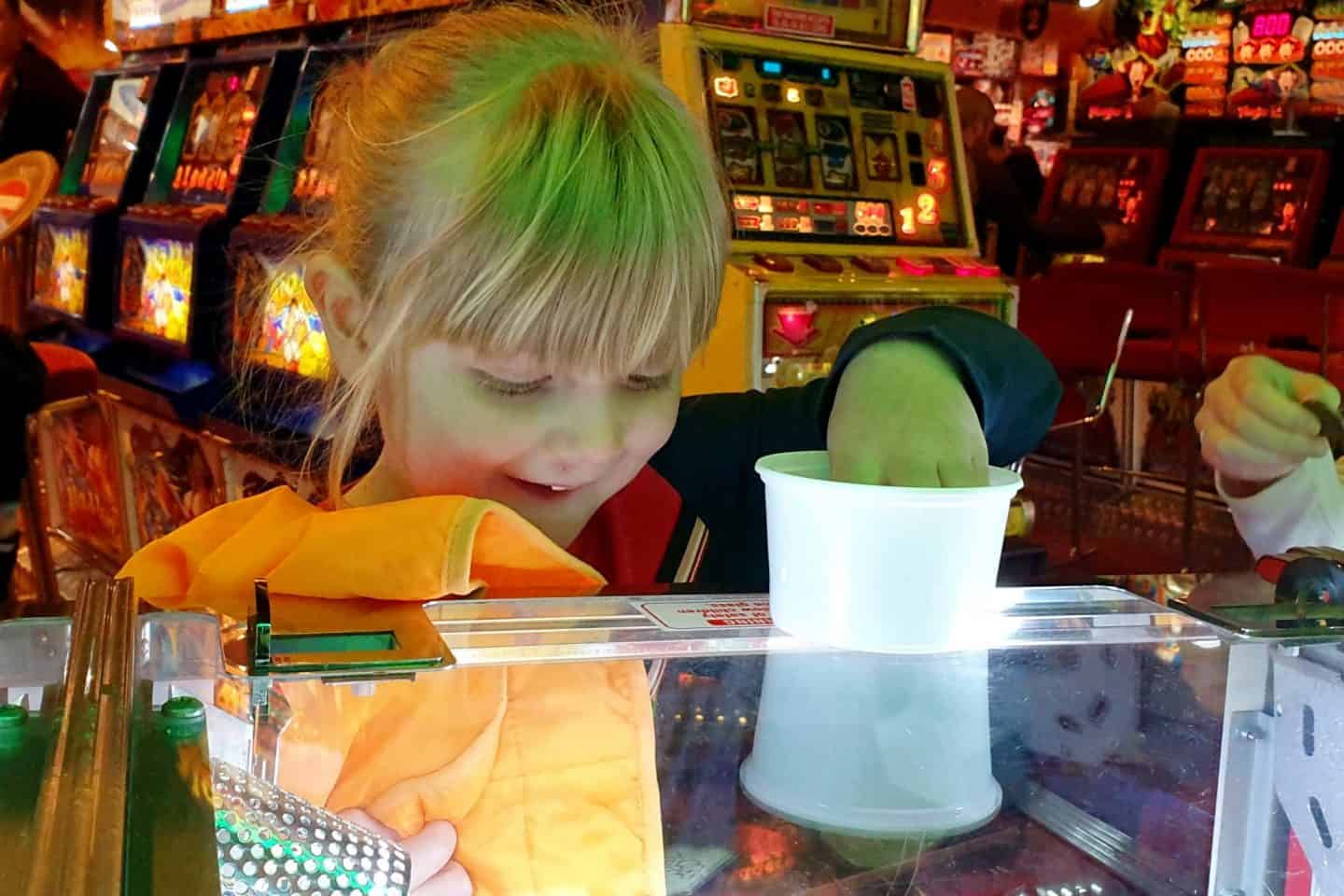 Little girl playing the 2p machines at arcades in Blackpool