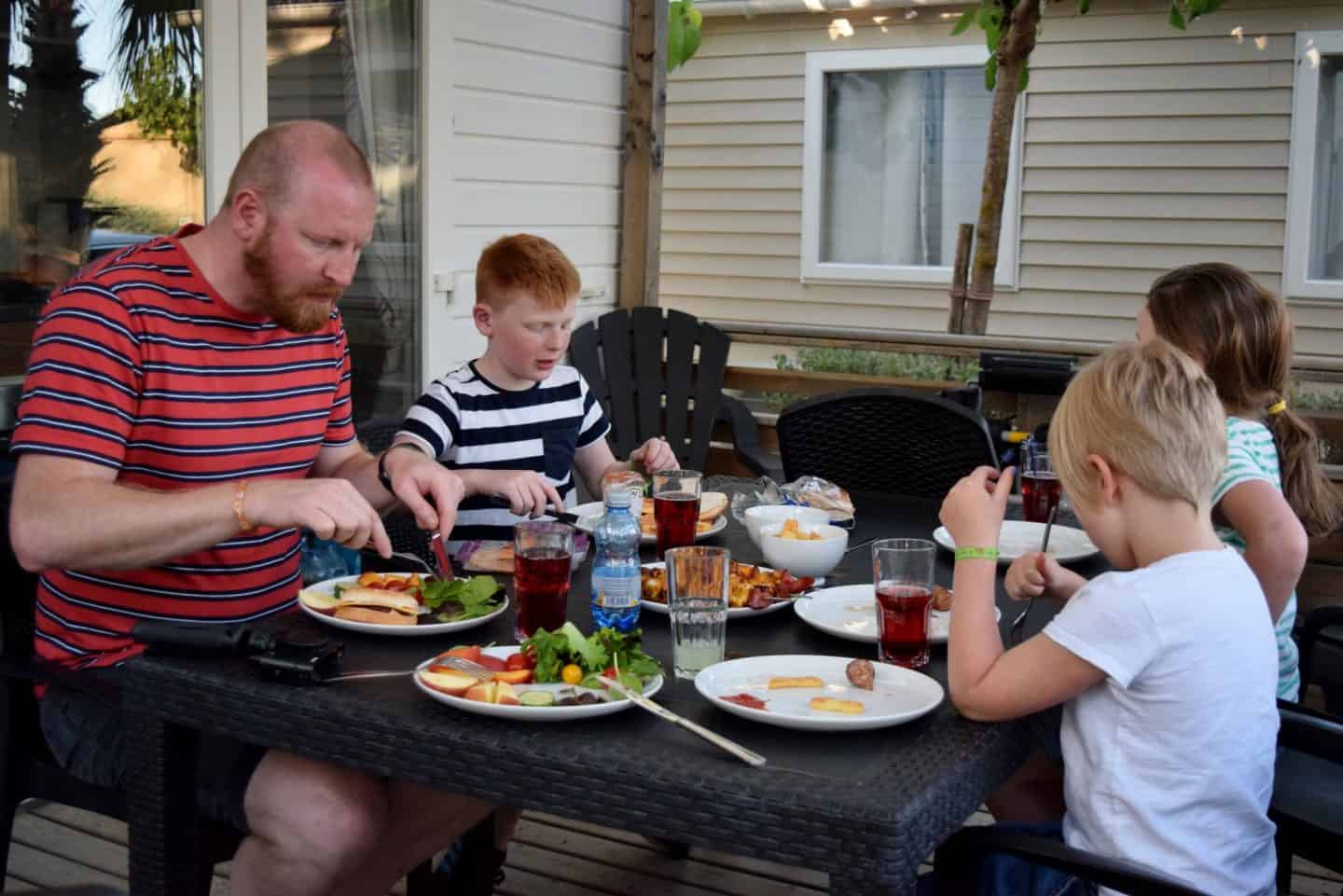 Family eating lunch on the deck of a Eurocamp Avant holiday home