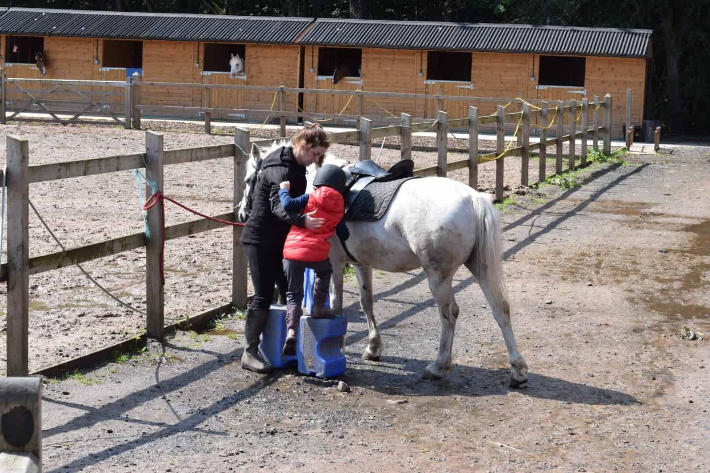 Little girl mounting a horse
