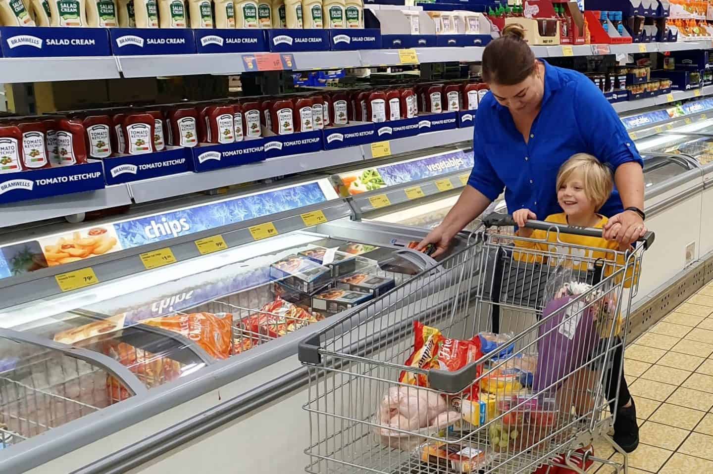 Mum shopping with little girl in Aldi - pushing shopping trolley