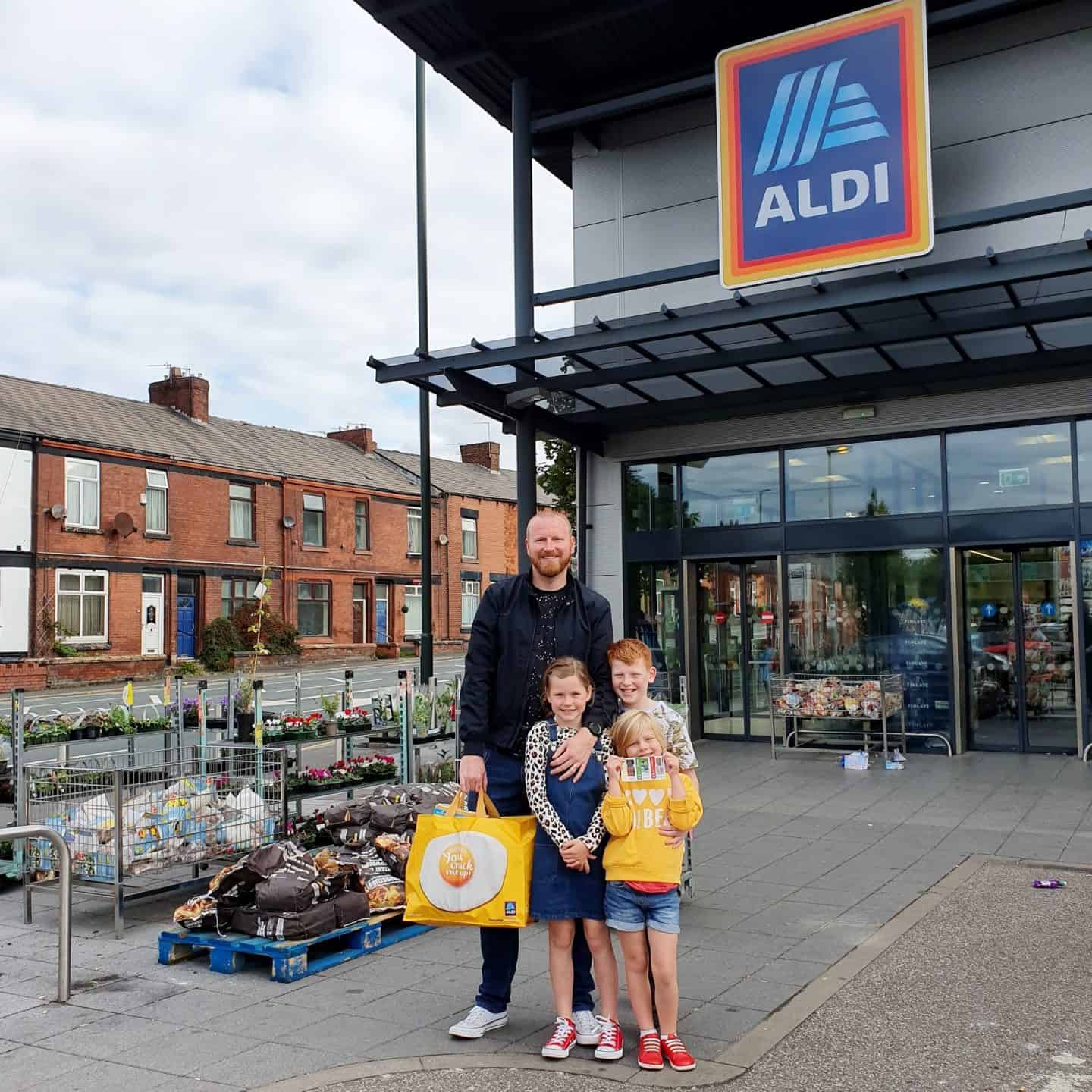 Dad and children outside ALDI with shopping bag