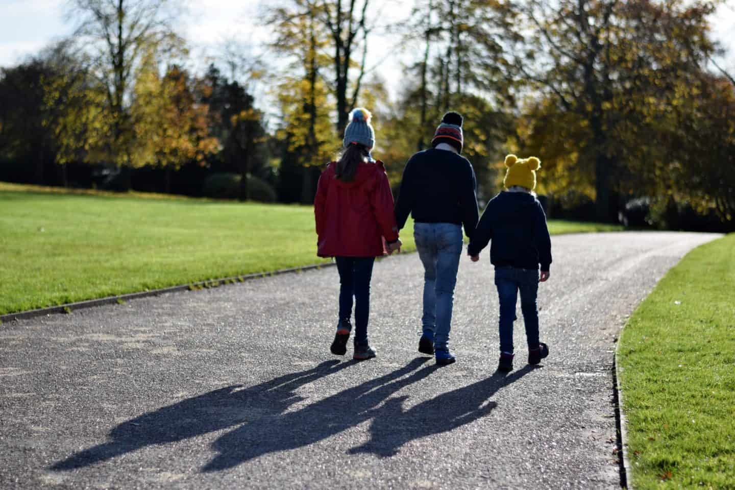 Three siblings walking in the autumn sunshine together