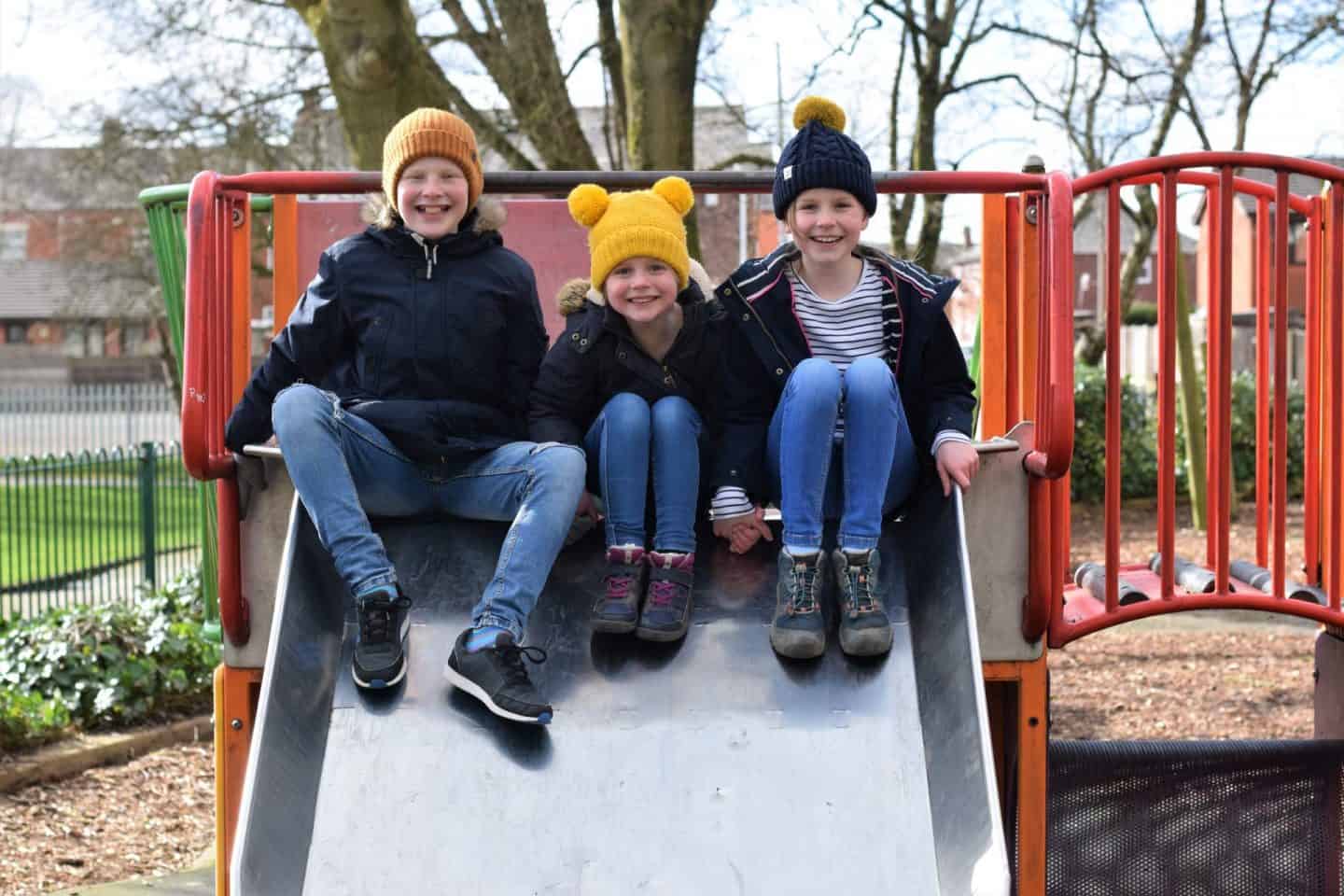 Siblings sitting at the top of the slide