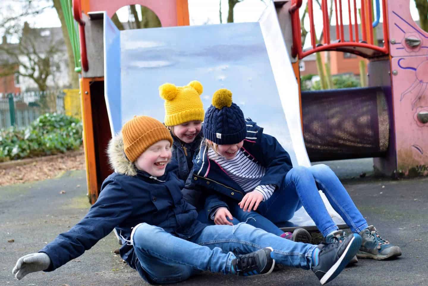 Kids falling off the bottom of the slide together