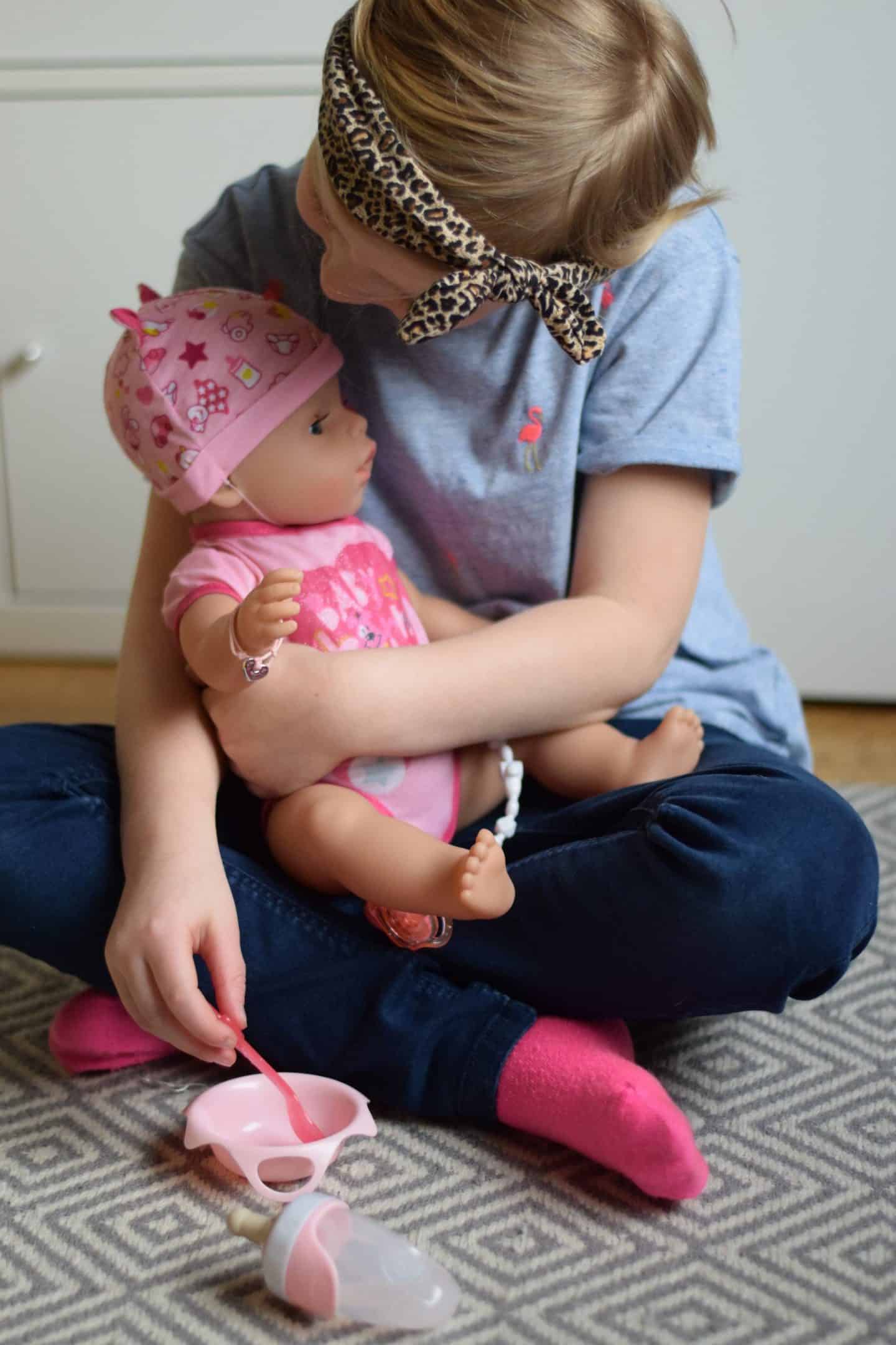 Little girl playing with a baby dolly