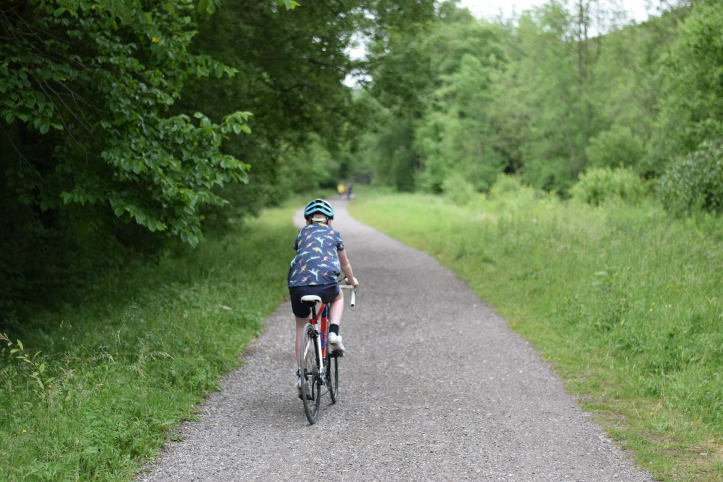 Boy riding a road bike on gravel path of Monsal Trail