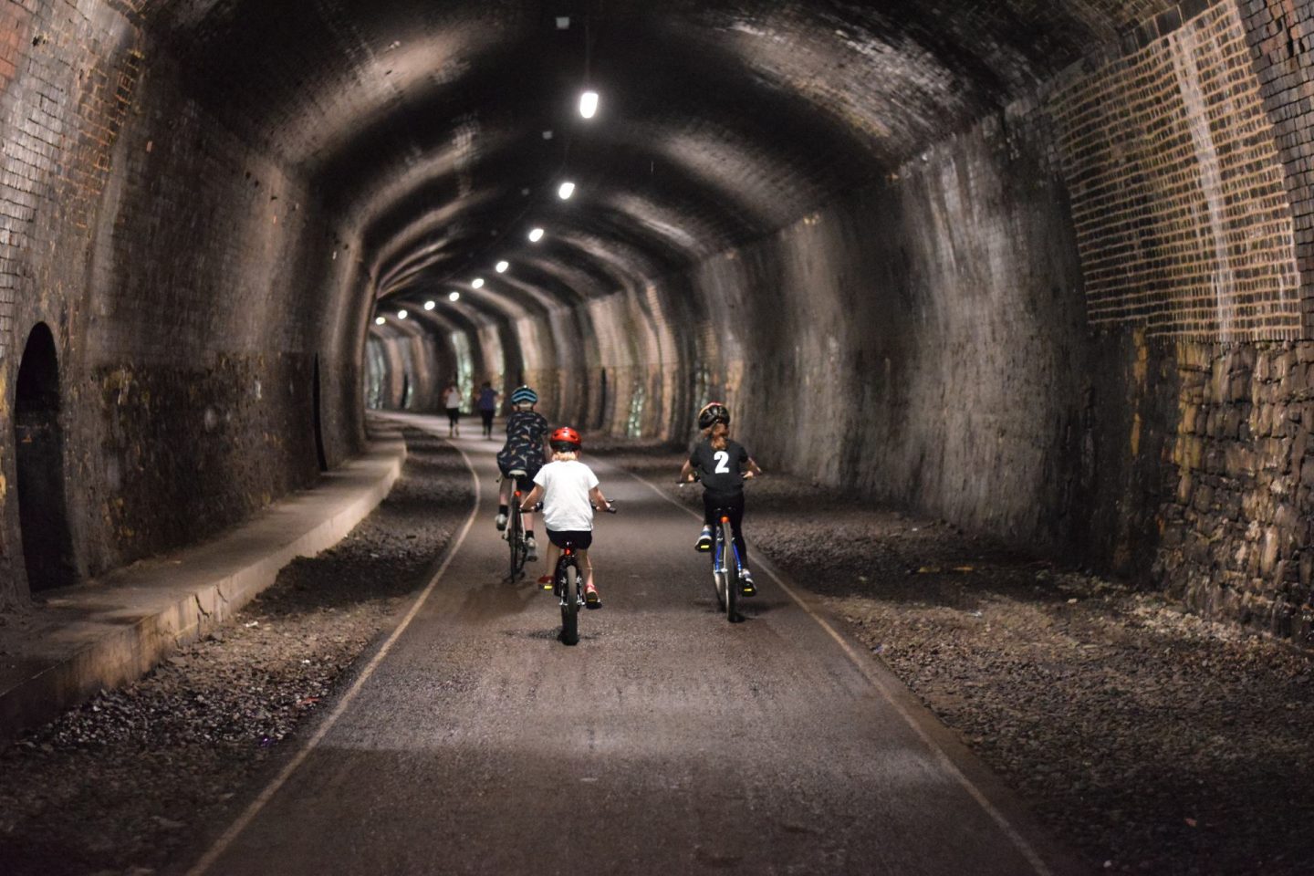 kids cycling through Monsal Trail tunnel