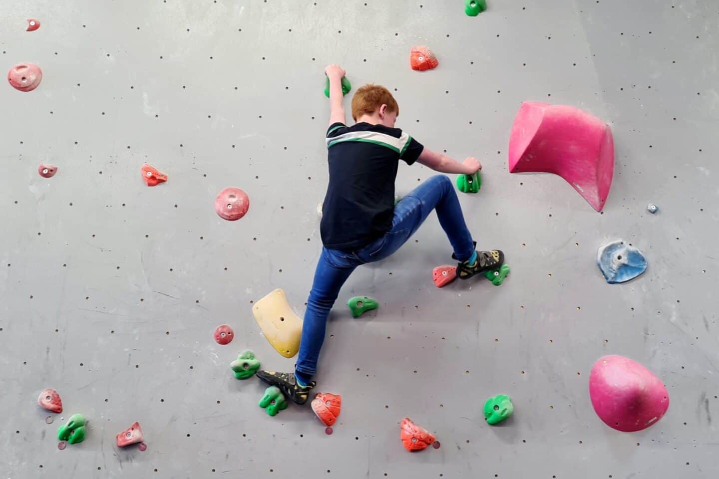 Ben conquering the green problems on the climbing wall