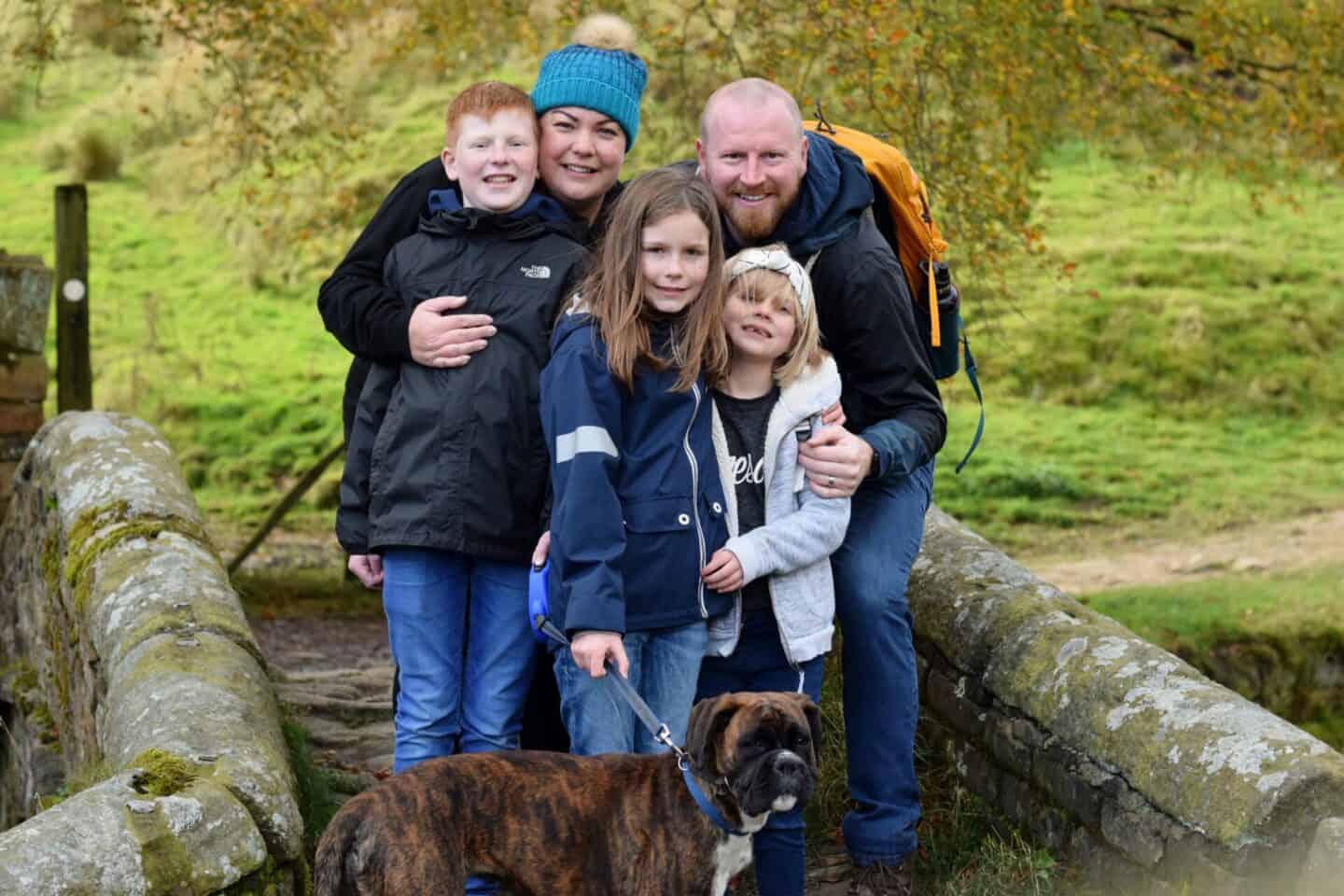 Family of five with a boxer puppy
