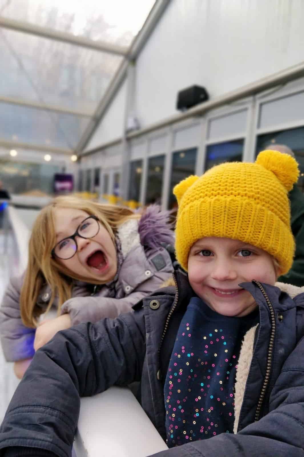Excited girls waiting to get on the ice rink at Cathedral Gardens Christmas ice rink