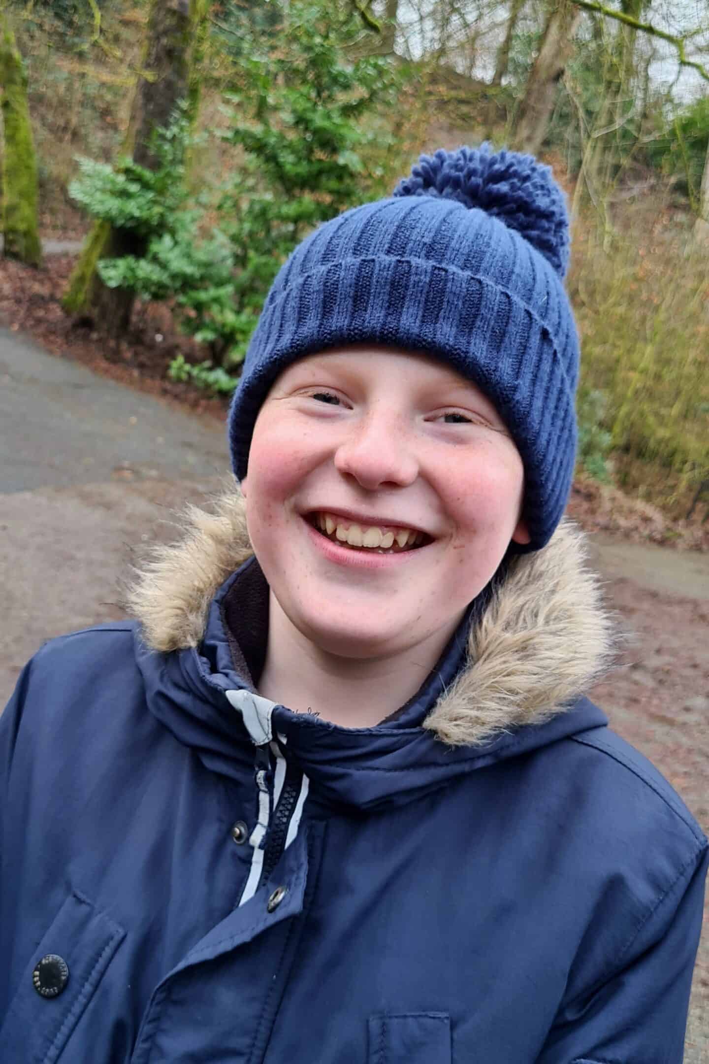 Tween wearing a parka and woolly hat on a winter walk